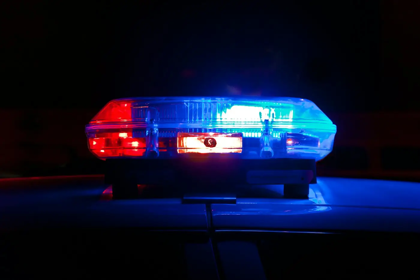 Police light bar glowing red and blue at night